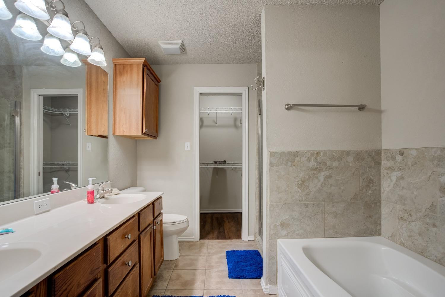 2101 Main Street, Unit 2 Lubbock, TX 79401 - Photo 24 of 31 a bathroom with a tub sink vanity and a mirror