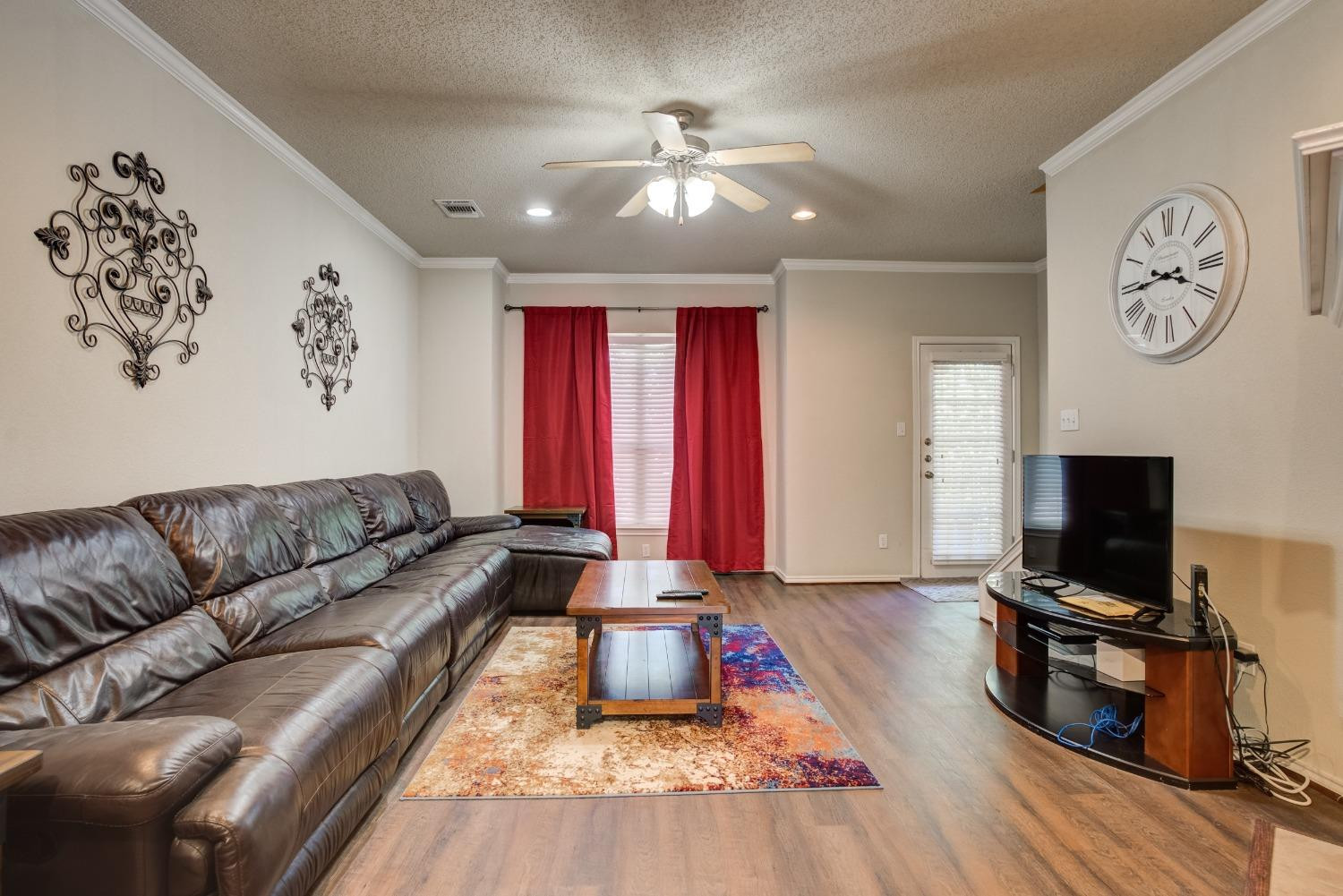 2101 Main Street, Unit 2 Lubbock, TX 79401 - Photo 5 of 31 a living room with furniture a flat screen tv and a fireplace