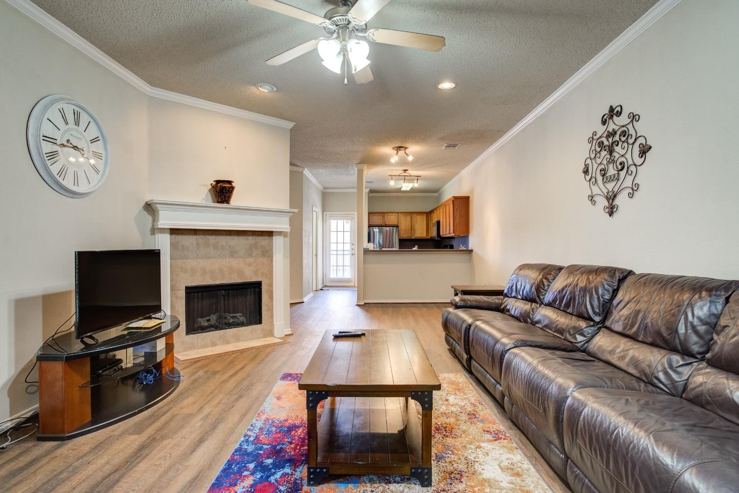 2101 Main Street, Unit 2 Lubbock, TX 79401 - Photo 7 of 31 a living room with furniture a clock on wall and a fireplace