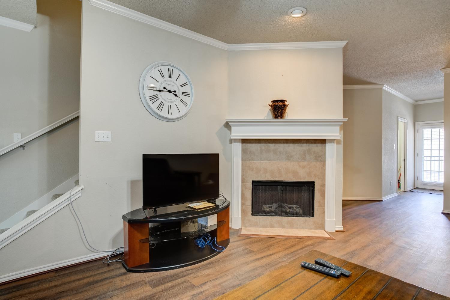 2101 Main Street, Unit 2 Lubbock, TX 79401 - Photo 9 of 31 a living room with a fireplace and a flat screen tv