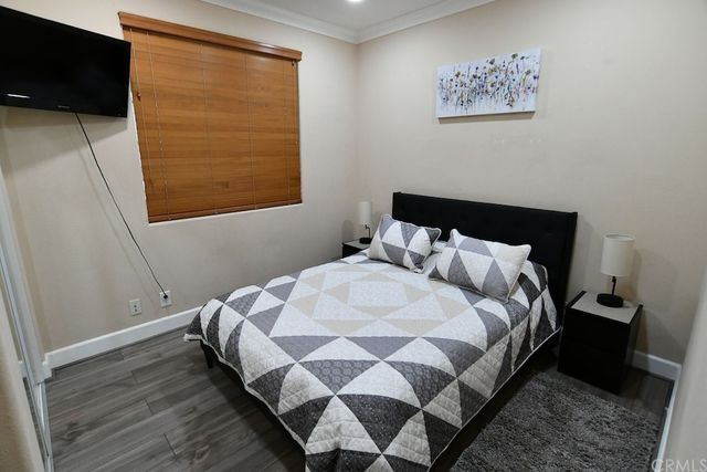 a bedroom with a bed and painting on the wall