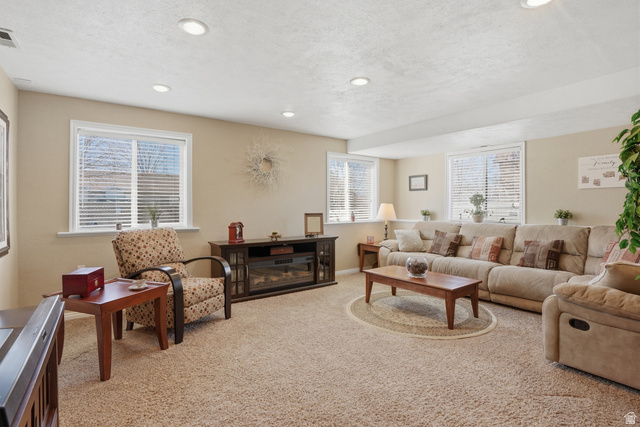 7737 Ranches Parkway Eagle Mountain, UT 84005 - Photo 17 of 28 Spacious living area featuring neutral-toned carpeting and recessed ceiling lighting