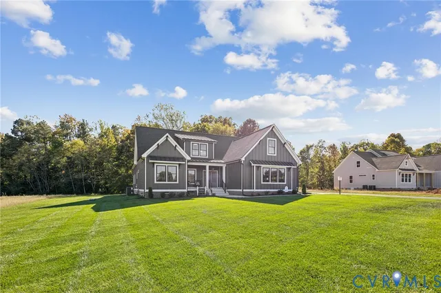 a view of a big house with a big yard and large trees