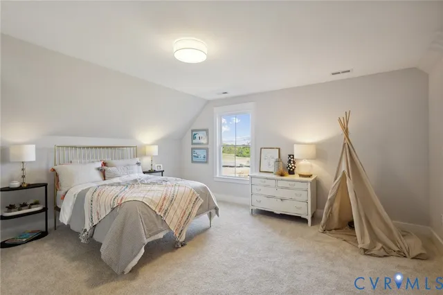 a bedroom with a bed mirror on desk and chair