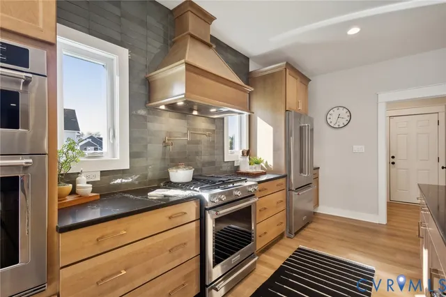 a kitchen with stainless steel appliances granite countertop a stove and a refrigerator