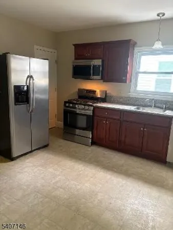 a kitchen with stainless steel appliances granite countertop a refrigerator and a stove