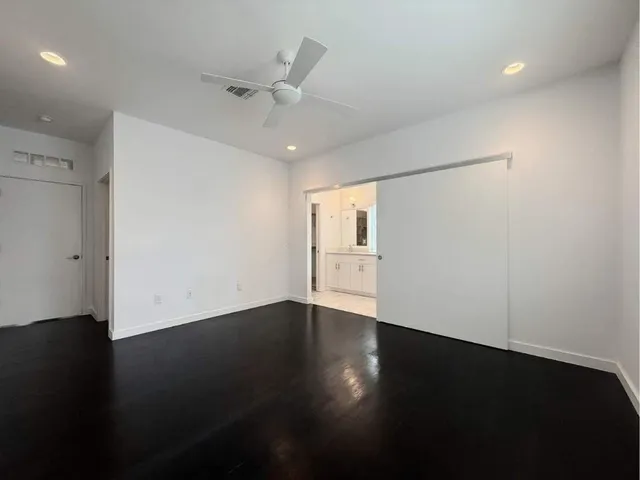 an empty room with wooden floor & windows