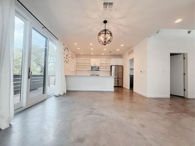 a kitchen with stainless steel appliances white cabinets a sink and a stove