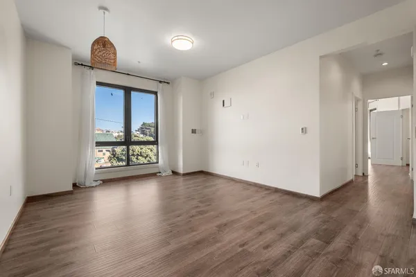 a view of a room with wooden floor and a window