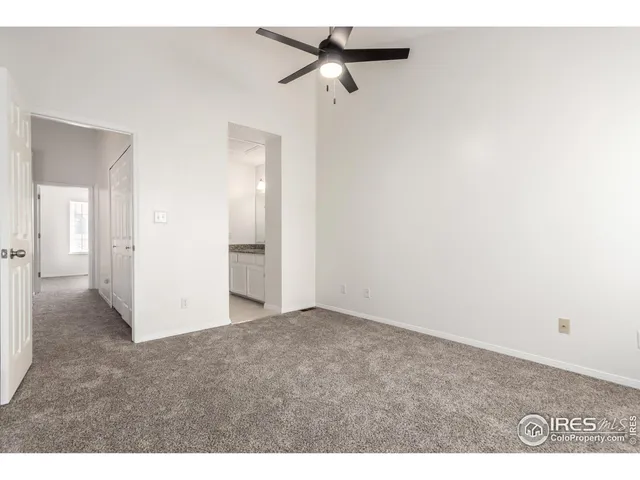 a view of a big room with an entryway and a ceiling fan