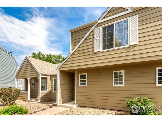 a view of a house with a small yard and wooden floor and fence