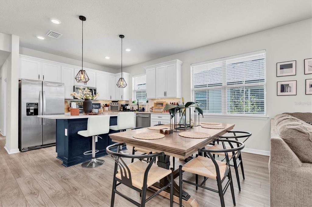 6352 Mooring Line Circle Apollo Beach, FL 33572 - Photo 13 of 33 a kitchen with stainless steel appliances kitchen island granite countertop a table chairs and a refrigerator