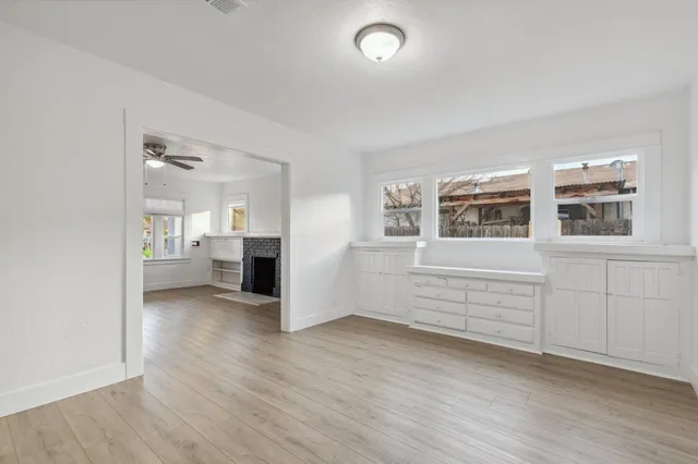 an empty room with wooden floor and windows