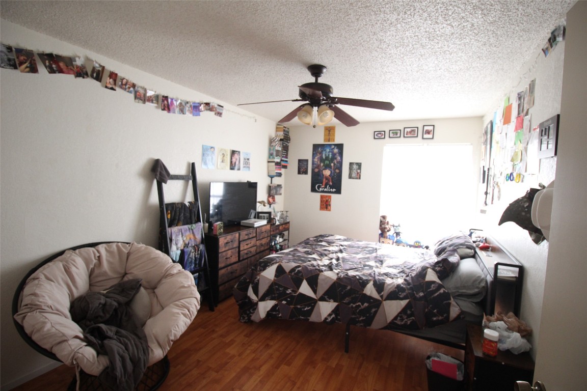 808 Angleton Cove Austin, TX 78748 - Photo 11 of 17 Bedroom with wood finished floors, a textured ceiling, and ceiling fan