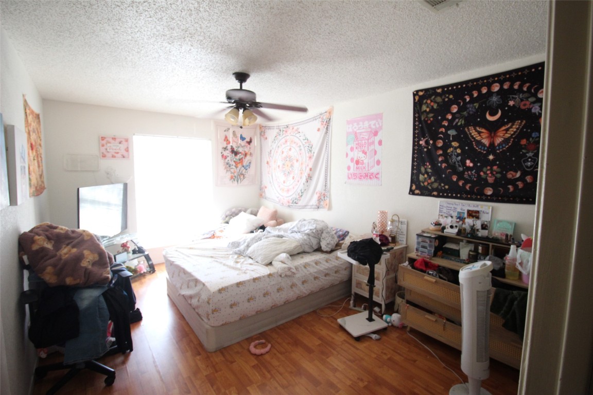 808 Angleton Cove Austin, TX 78748 - Photo 9 of 17 Bedroom with wood finished floors, a textured ceiling, and ceiling fan