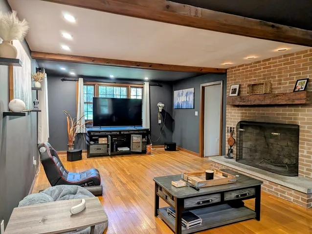 a living room with furniture a flat screen tv and a fireplace