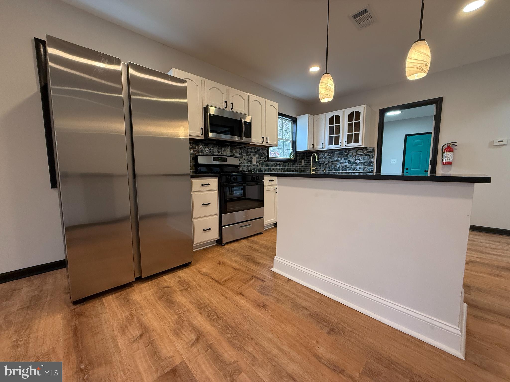 11 Sunset Lane Bridgeton, NJ 08302 - Photo 5 of 16 a kitchen with stainless steel appliances granite countertop a refrigerator a stove a microwave oven a sink with wooden floor and cabinets