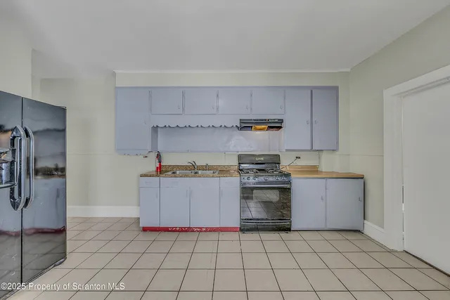 a kitchen with a stove top oven and cabinets
