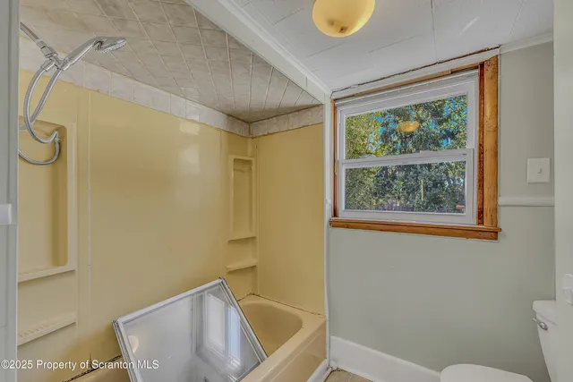 a bathroom with a tub and window