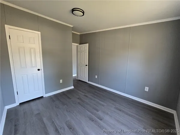 a view of an empty room with wooden floor