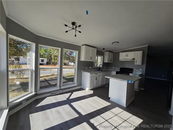 a kitchen with granite countertop a stove a sink and a refrigerator