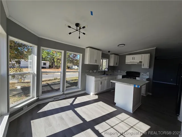 a kitchen with granite countertop a stove a sink and a refrigerator