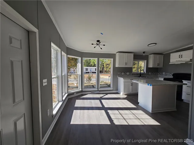 a kitchen with granite countertop a stove a sink and a refrigerator