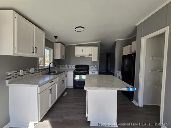 a kitchen with a stove top oven a sink a refrigerator and cabinets