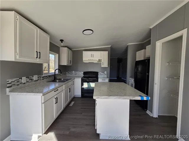 a kitchen with a stove top oven a sink a refrigerator and cabinets