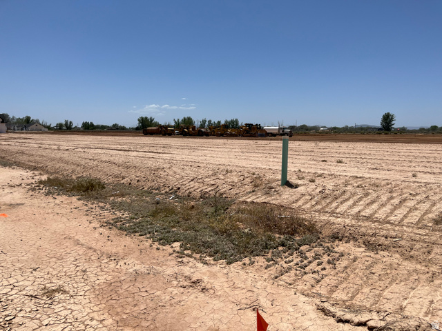 5107 North 75 East, Unit 207 Enoch, UT 84721 - Photo 5 of 13 Expansive undeveloped lot featuring a clear, level terrain and a visible utility marker
