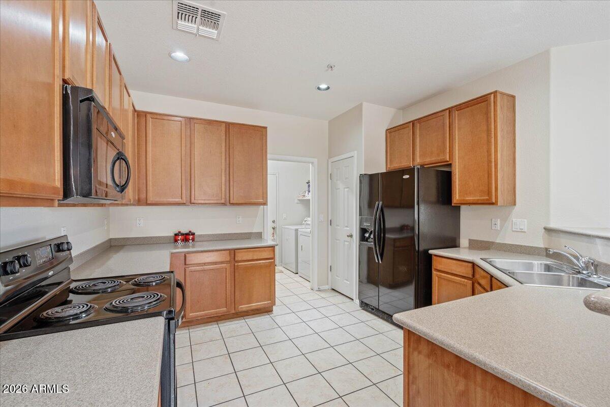 1255 South Rialto, Unit 106 Mesa, AZ 85209 - Photo 3 of 32 a kitchen with a sink a refrigerator and cabinets
