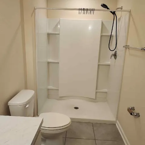 a bathroom with a toilet and a shower