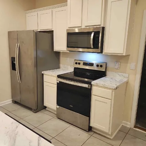 a kitchen with stainless steel appliances a stove microwave and refrigerator