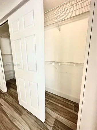 a view of a small room with wooden floor and cabinet
