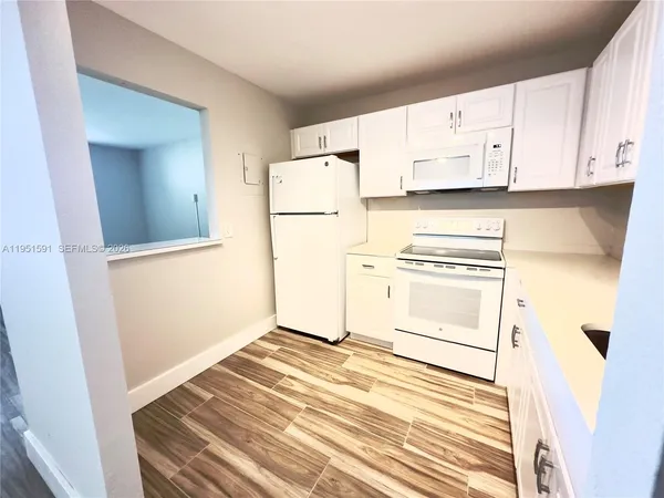 a kitchen with white cabinets and white appliances