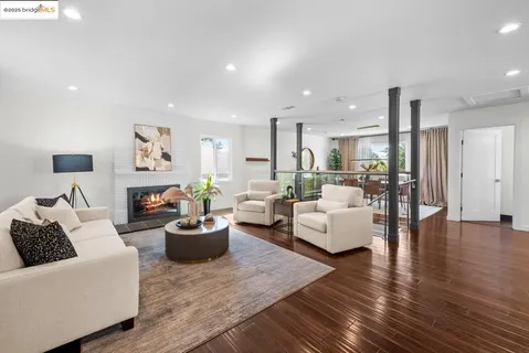 a kitchen with stainless steel appliances granite countertop a refrigerator a sink dishwasher a stove and white countertops with wooden floor