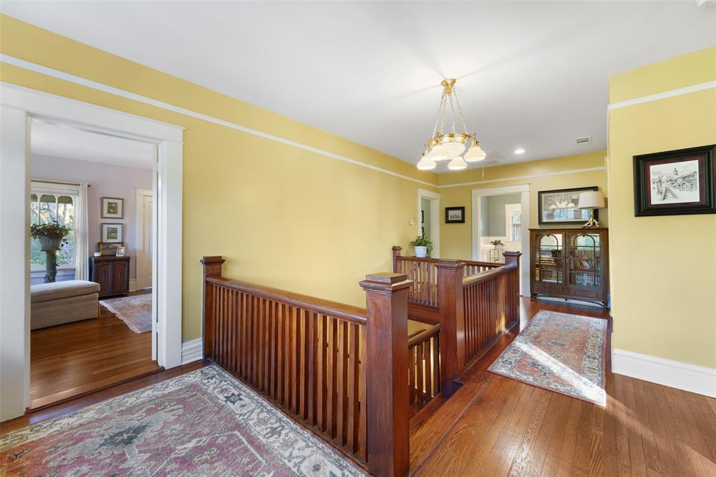 406 Griffith Avenue Terrell, TX 75160 - Photo 27 of 40 This area features hardwood floors, a wooden banister, and a decorative chandelier