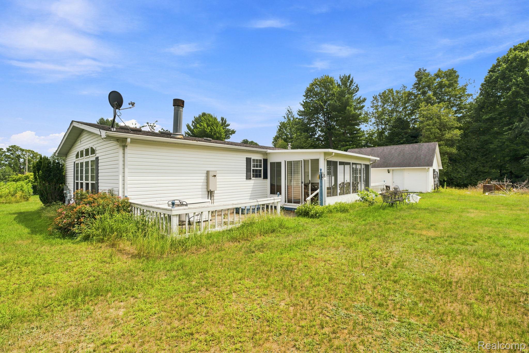 2390 Lakeshore Road Applegate, MI 48401 - Photo 35 of 97 White siding exterior with a screened-in porch, a wooden deck, and a detached structure