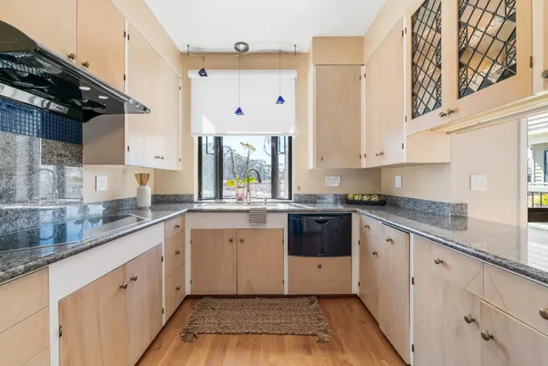 a large kitchen with stainless steel appliances granite countertop a sink and cabinets with wooden floor