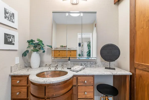 a bathroom with a granite countertop sink a mirror and vanity