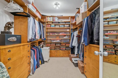 a view of walk in closet with clothes and shoes