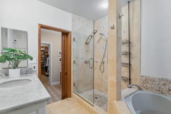 a bathroom with a granite countertop tub shower and sink