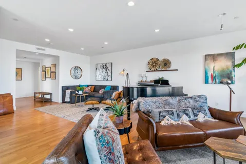 a living room with furniture and a wooden floor