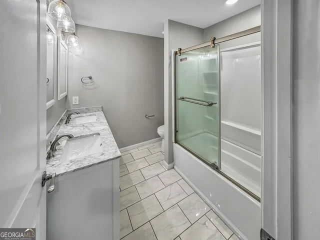 a bathroom with a granite countertop sink mirror and shower