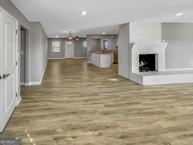 an empty room with wooden floor and fireplace