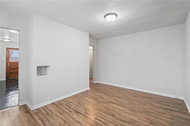 a view of an empty room with wooden floor