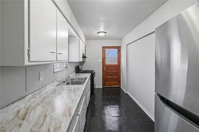 a kitchen with stainless steel appliances granite countertop a refrigerator and a stove