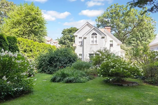 a view of a house with a yard and potted plants
