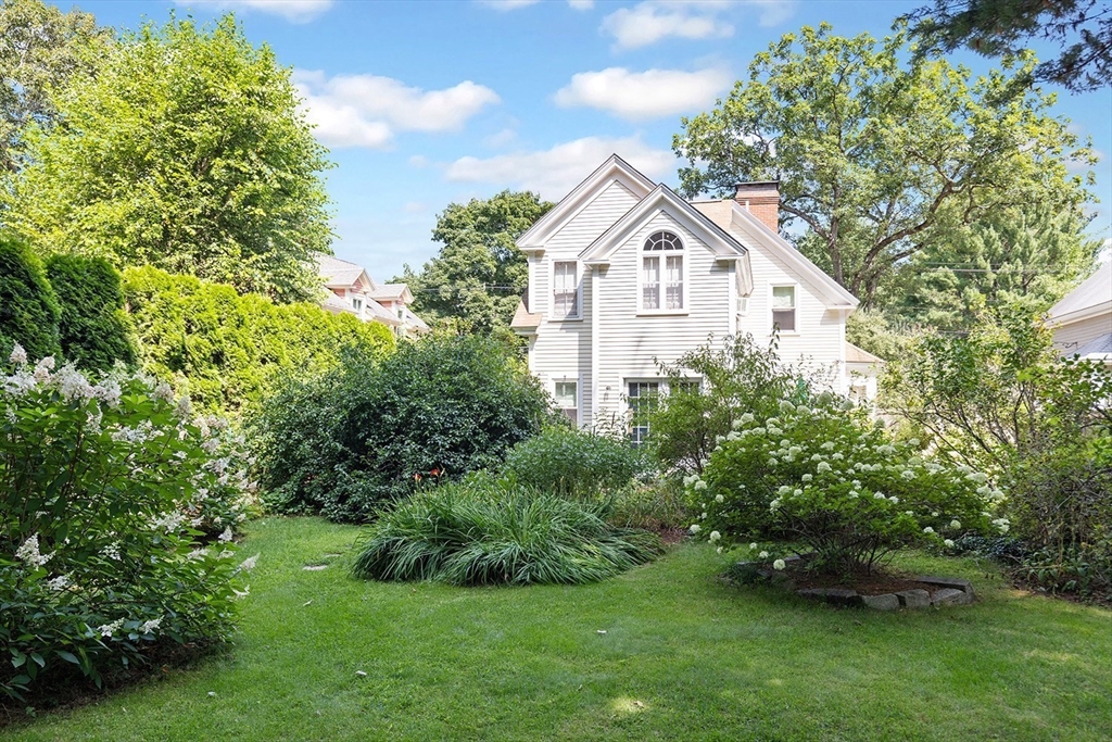 a view of a house with a yard and potted plants