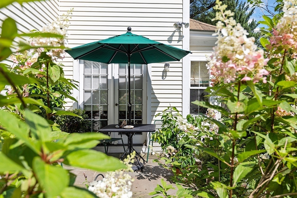 855 Barretts Mill Road Concord, MA 01742 - Photo 14 of 15 a backyard of a house with table and chairs under an umbrella